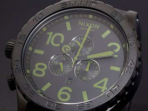 Close-up detail of Nixon 51-30 Surplus dial with lime green numerals, indices, and chronograph subdials