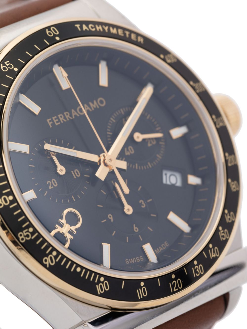 Close-up of black dial showing chronograph subdials, tachymeter bezel, and gold-tone hands