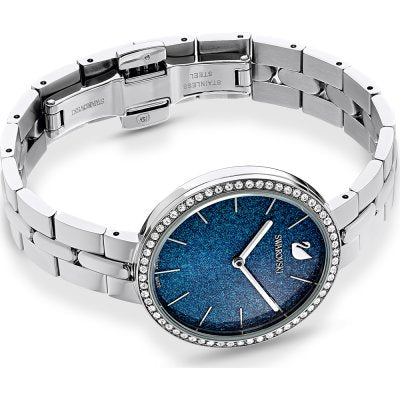 Swarovski women's watch on wrist displaying blue dial and silver steel bracelet