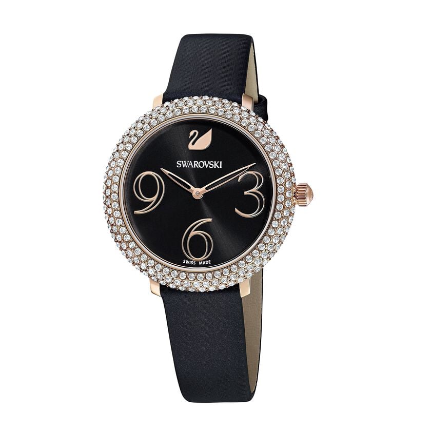 Angled view of Swarovski watch showing crystal-set bezel, black dial with rose gold numerals, and black leather strap