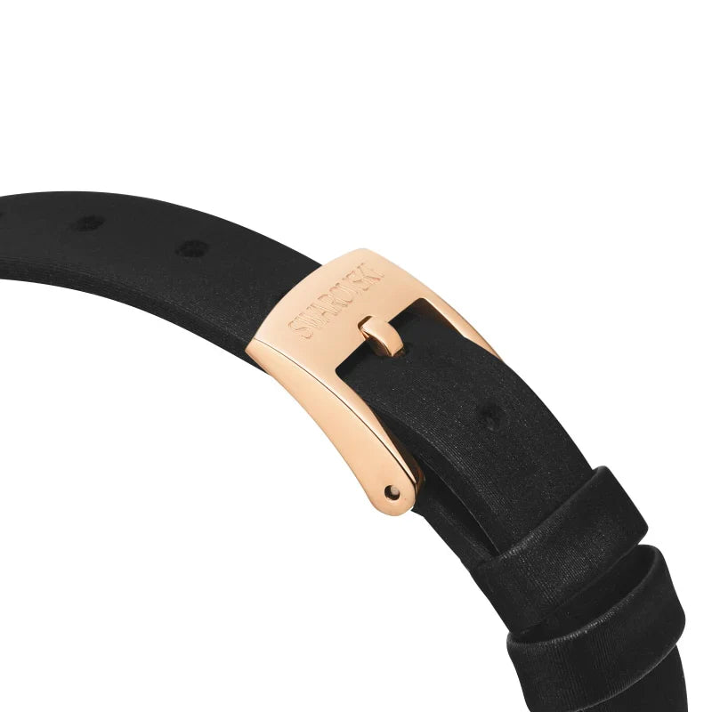 Closeup of rose gold buckle and black leather strap with Swarovski branding