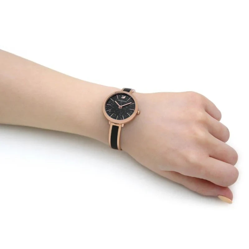 Swarovski Crystalline Delight watch worn on wrist with black dial and rose-gold two-tone band