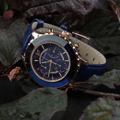 Swarovski Crystalline Glam watch worn on wrist showing blue dial and rose gold chronograph case