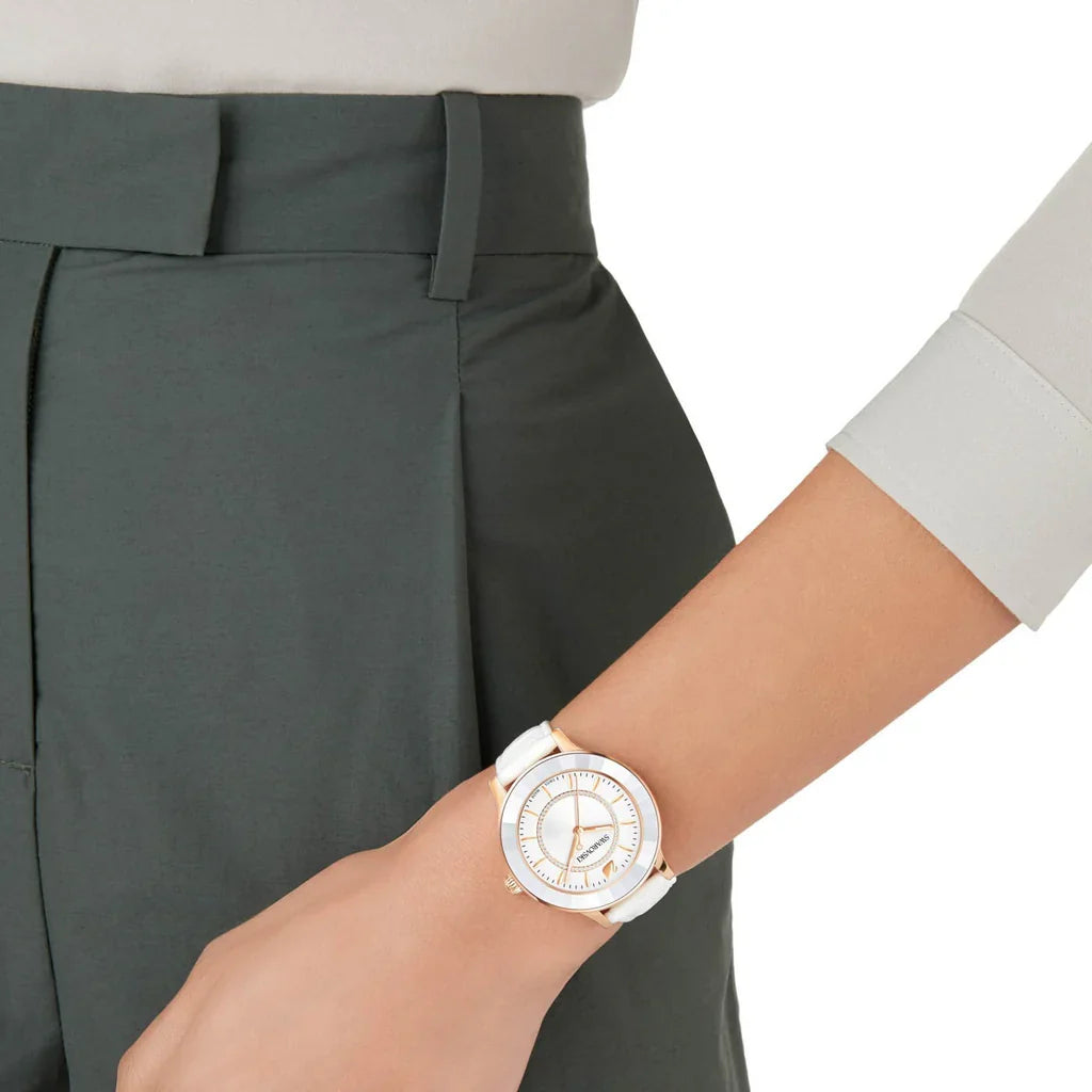 Swarovski Octea Lux watch worn on wrist showing white dial and rose gold case with white leather strap