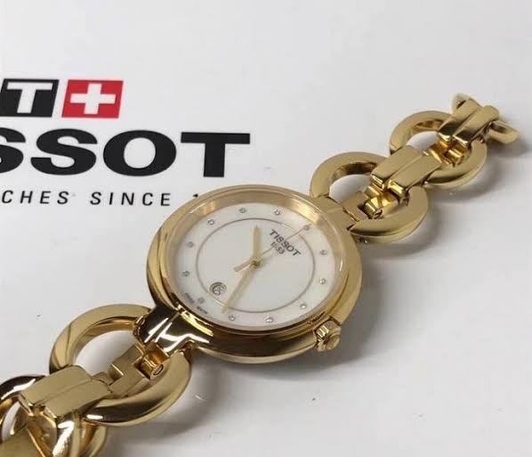 Tissot Flamingo gold-tone women's watch worn on wrist with Tissot branding visible