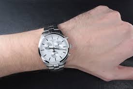 Tissot PR 100 chronograph watch worn on wrist showing white dial and steel bracelet