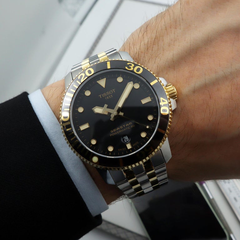 Tissot Seastar 1000 Powermatic 80 worn on wrist showing black dial and two-tone bracelet