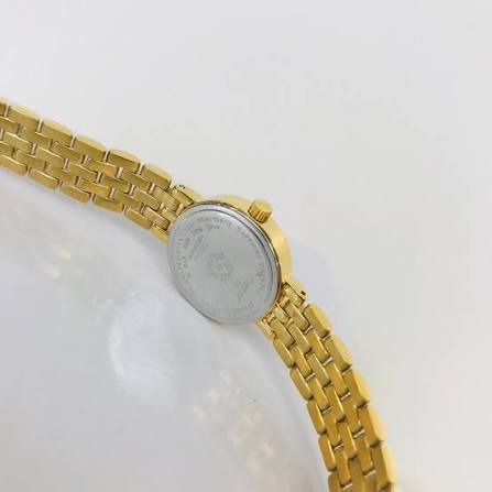 Side profile of Tissot T-Lady Lovely watch showing gold steel bracelet and case thickness