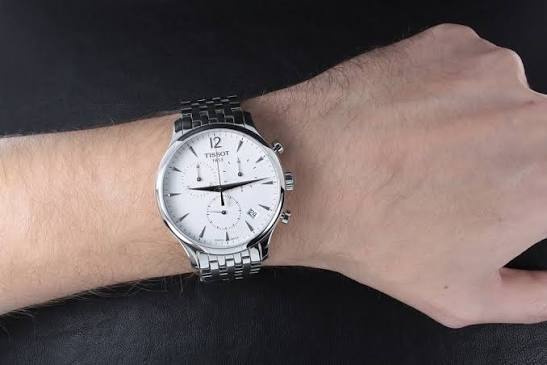 Tissot Tradition chronograph watch worn on wrist with silver bracelet
