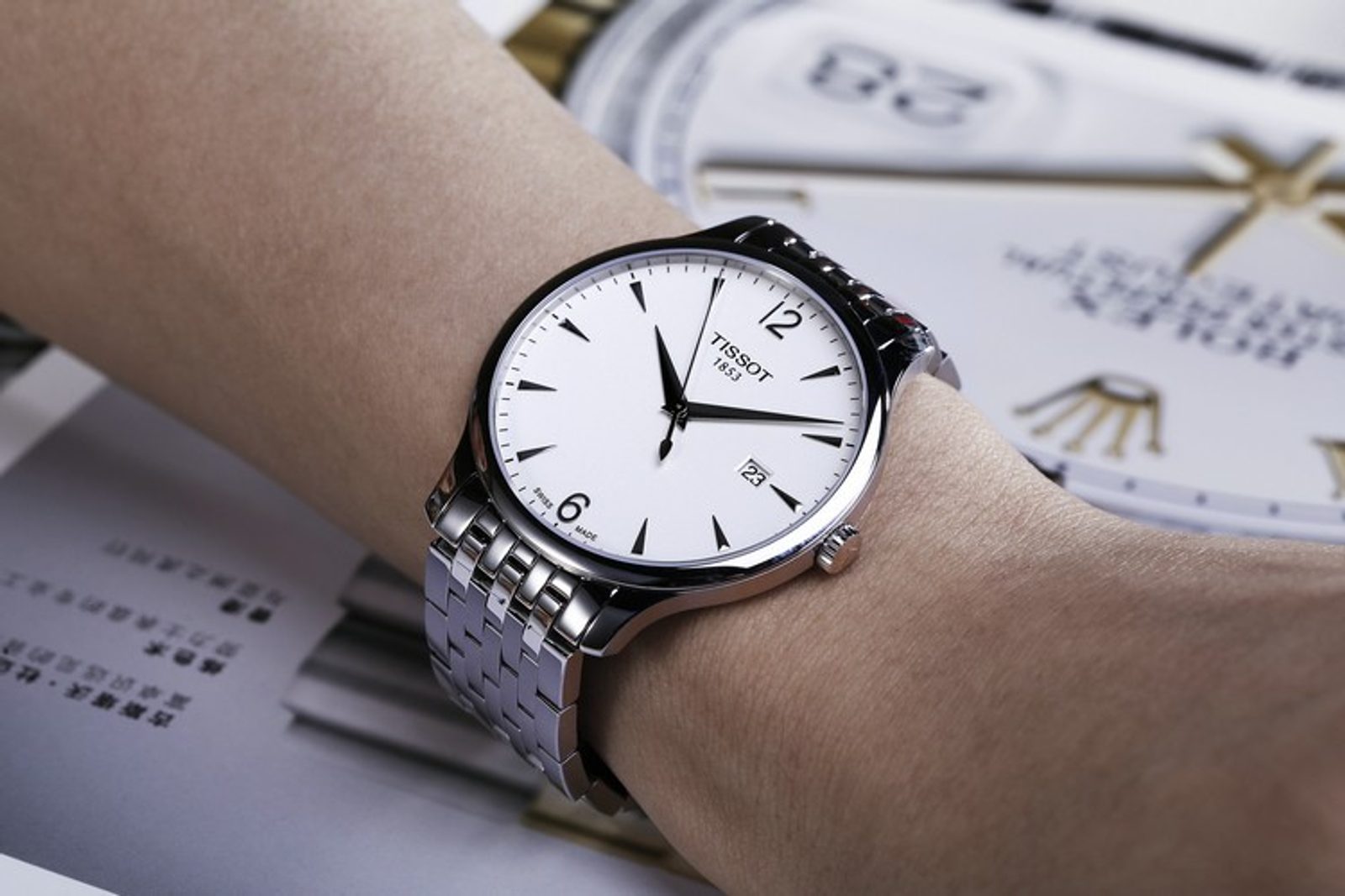 Tissot Tradition watch worn on wrist with white dial and stainless steel band