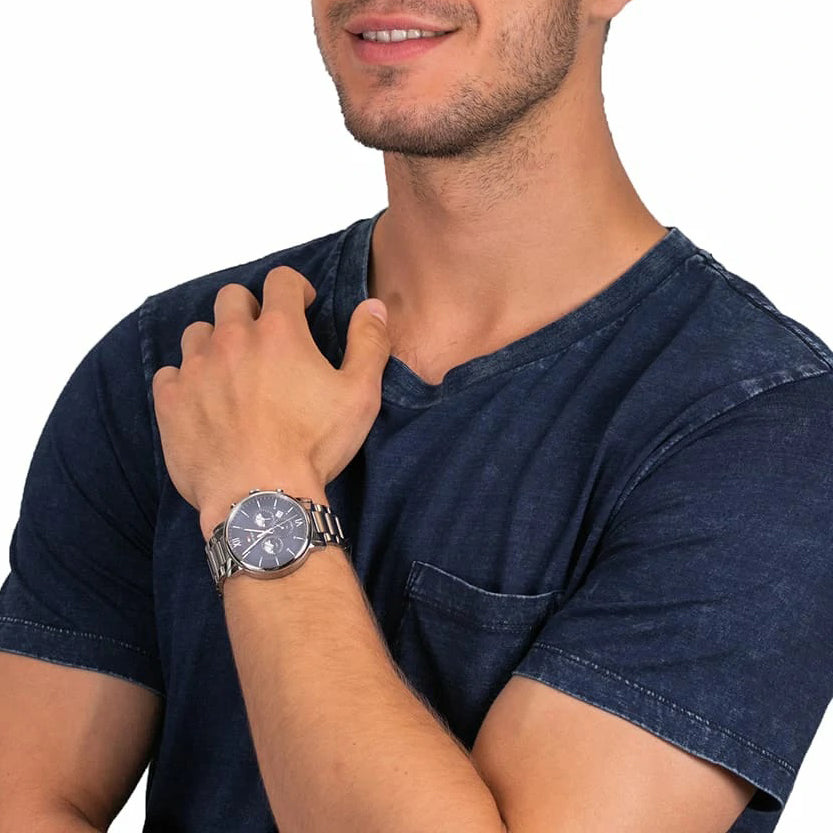 Tommy Hilfiger chronograph watch worn on men's wrist with blue dial and silver bracelet