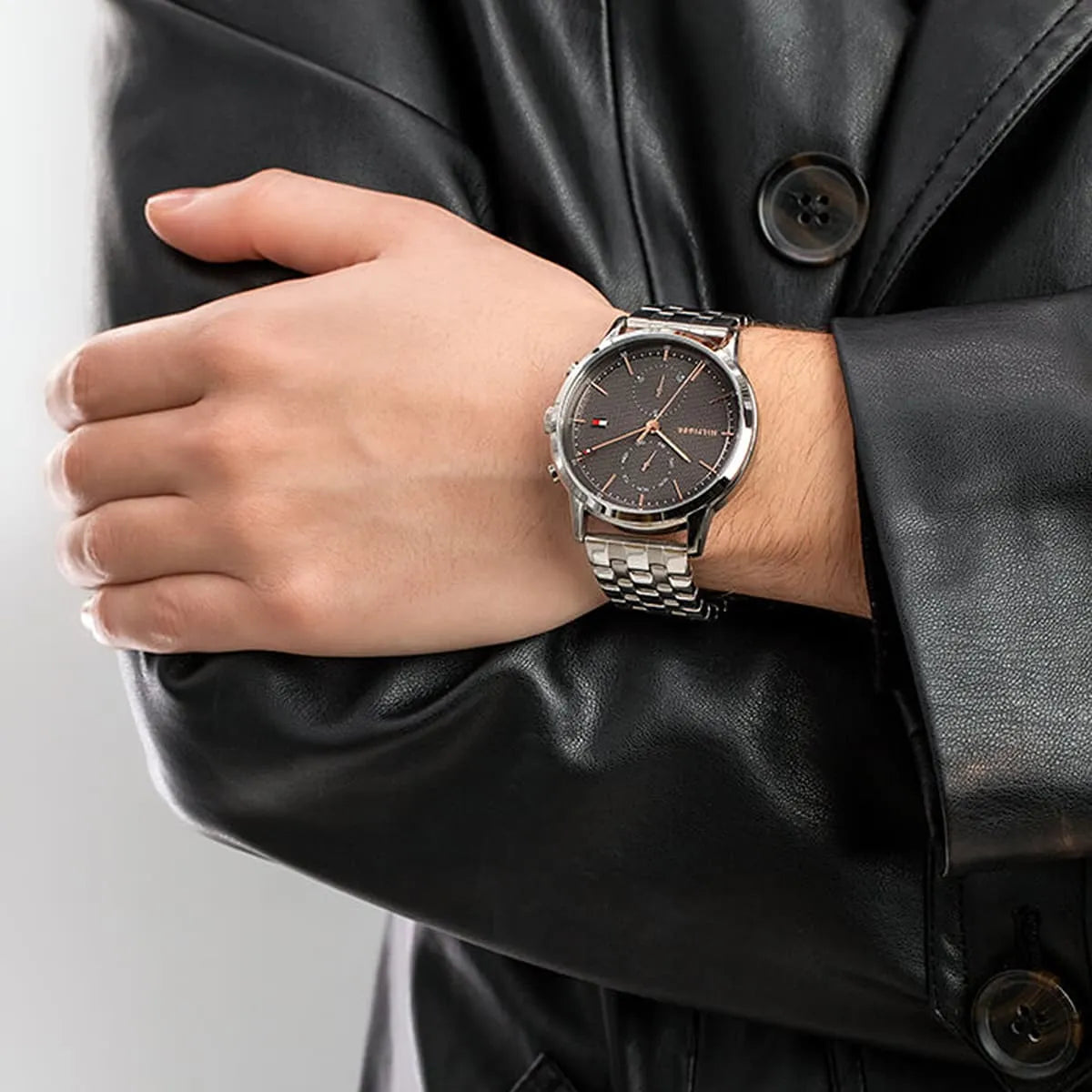 Tommy Hilfiger 1710431 watch on wrist with formal black jacket styling
