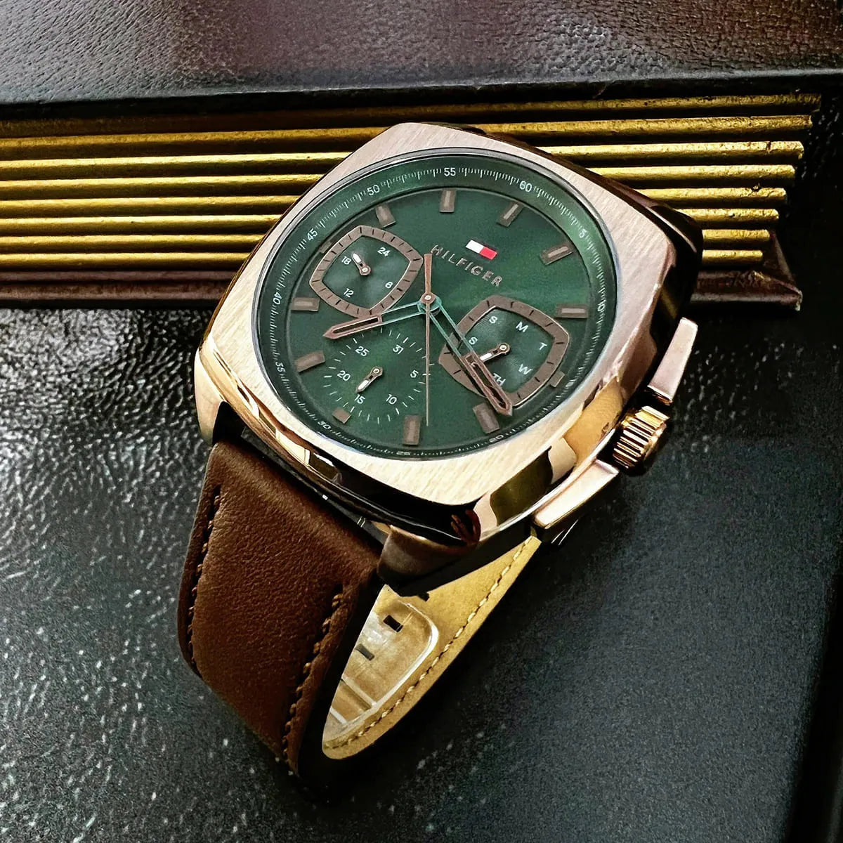 Close-up of green dial with chronograph subdials, gold indices, and rose-tone hands