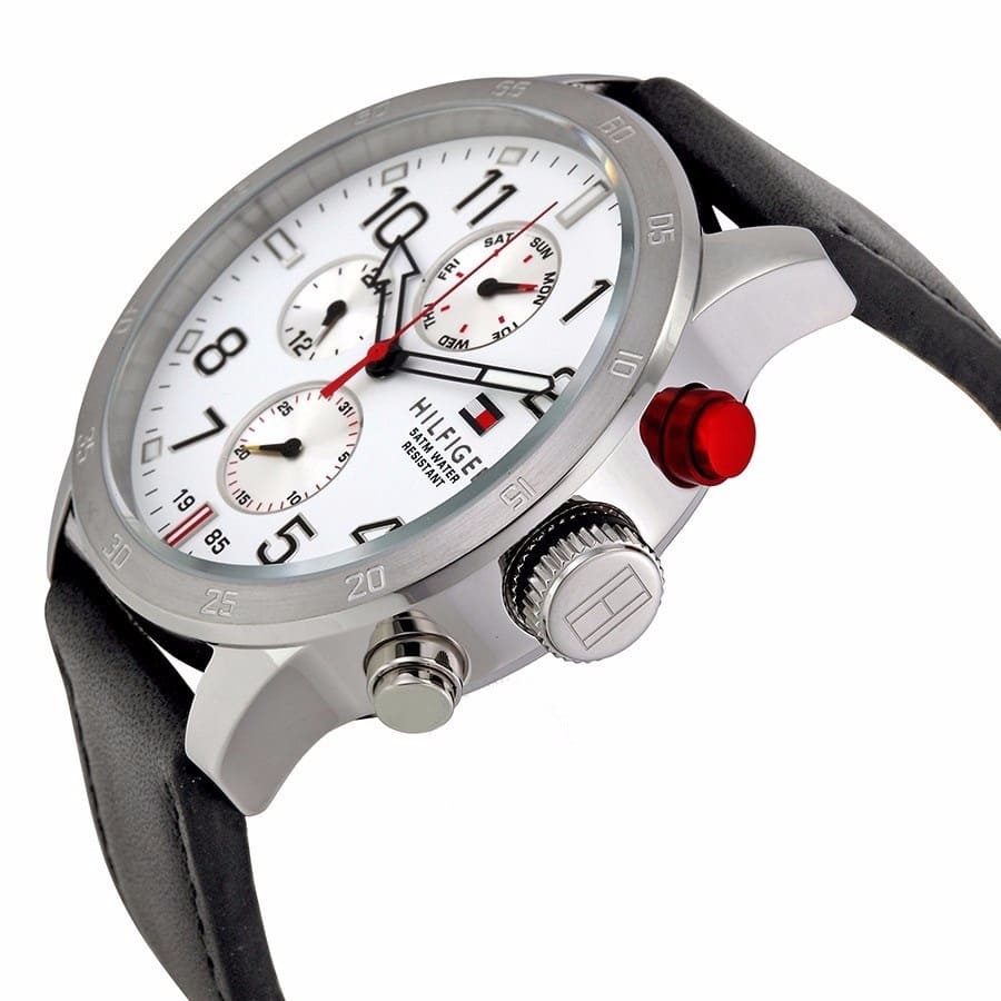 Side angle view of Tommy Hilfiger watch showing white chronograph dial, red accents, and crown detail