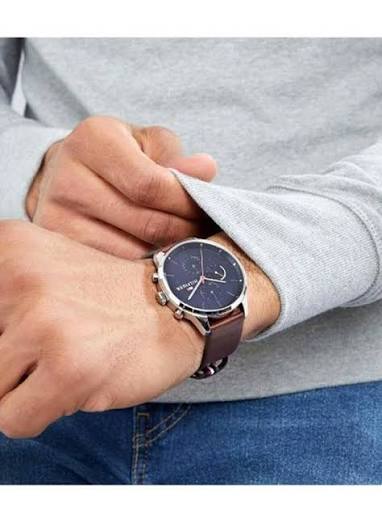 Tommy Hilfiger 1791487 chronograph watch on wrist with navy dial and brown leather strap