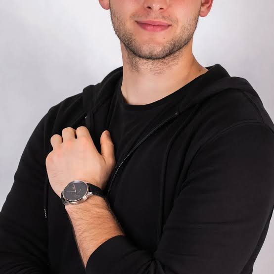 Tommy Hilfiger watch worn on man's wrist with black silicone strap
