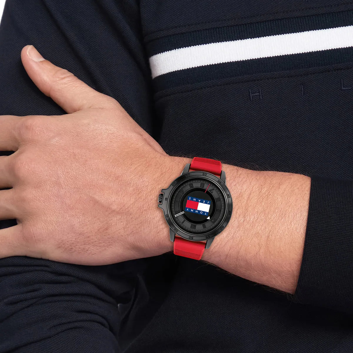 Tommy Hilfiger watch worn on wrist showing black case and red rubber strap in use