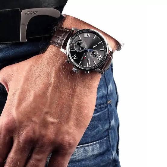 Tommy Hilfiger Alden black chronograph watch worn on wrist with brown leather strap