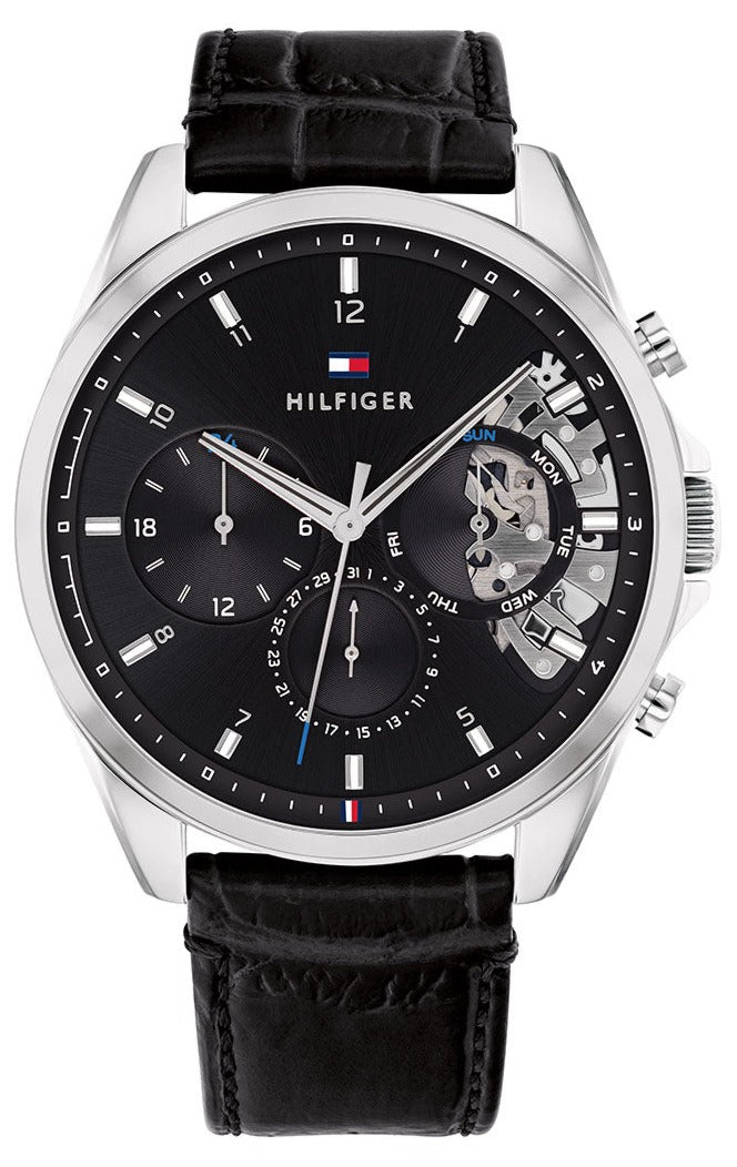 Tommy Hilfiger Baker chronograph watch with black dial and black leather strap, showing open heart skeleton window
