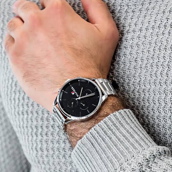 Tommy Hilfiger Chase watch worn on wrist with silver steel band and black dial