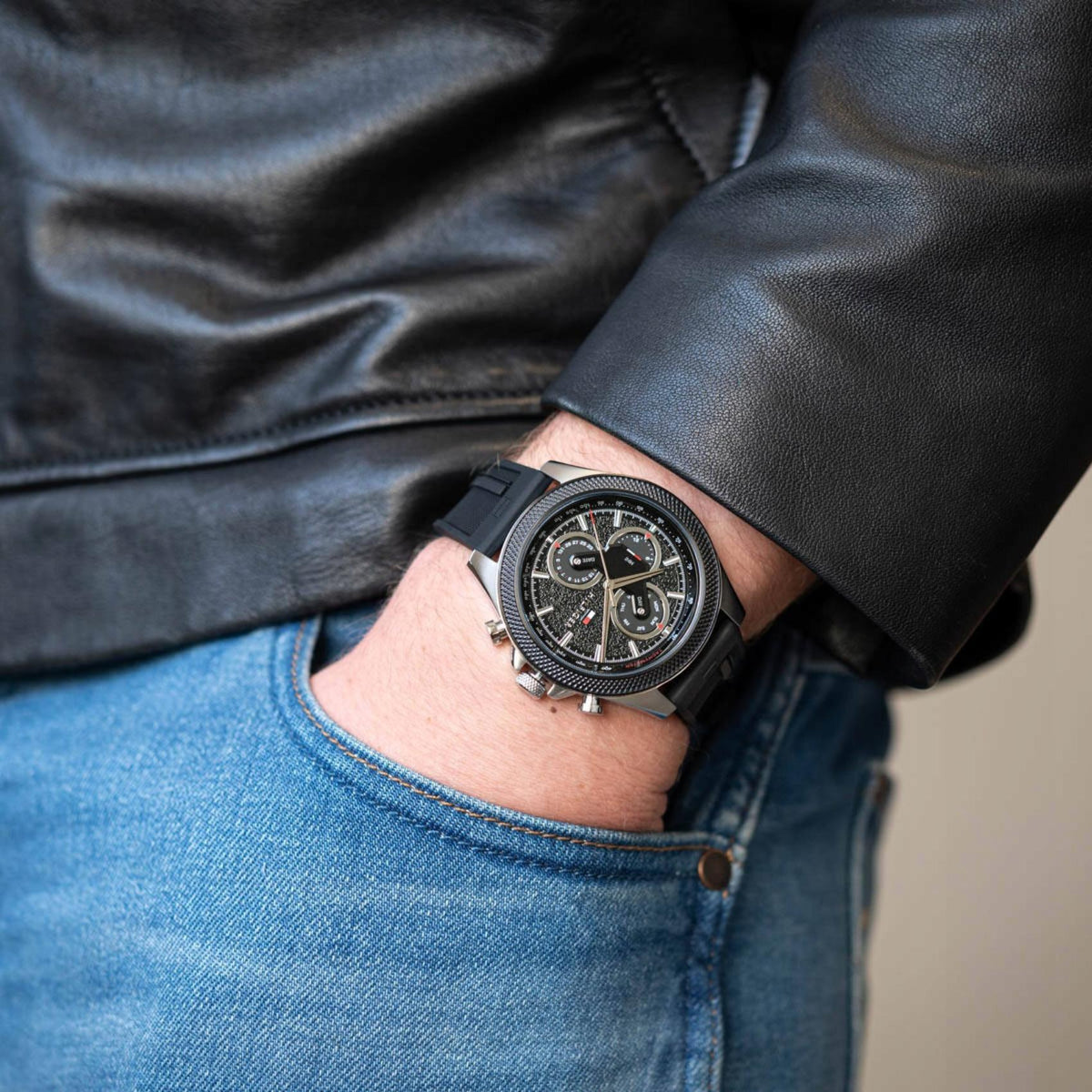 Tommy Hilfiger Clark watch worn on wrist with blue jeans and black leather jacket visible