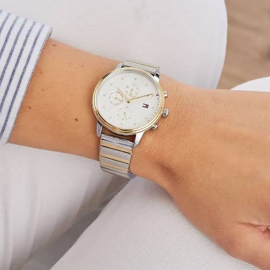 Two-tone gold and silver chronograph watch worn on wrist with white dial and metal bracelet