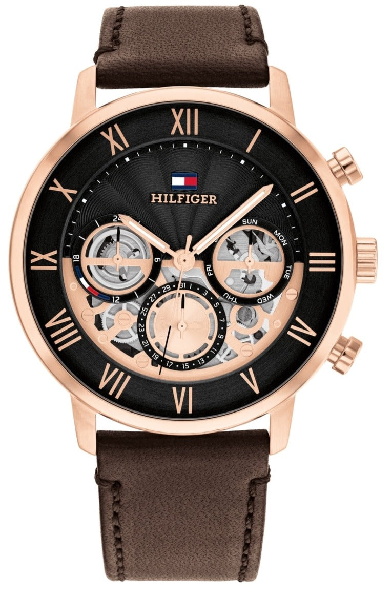 Tommy Hilfiger LEGEND watch with black dial, rose gold case, roman numerals, and brown leather strap