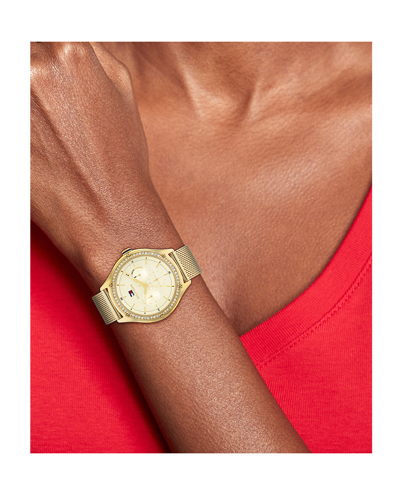 Tommy Hilfiger Lexi watch worn on wrist with gold mesh strap and champagne dial