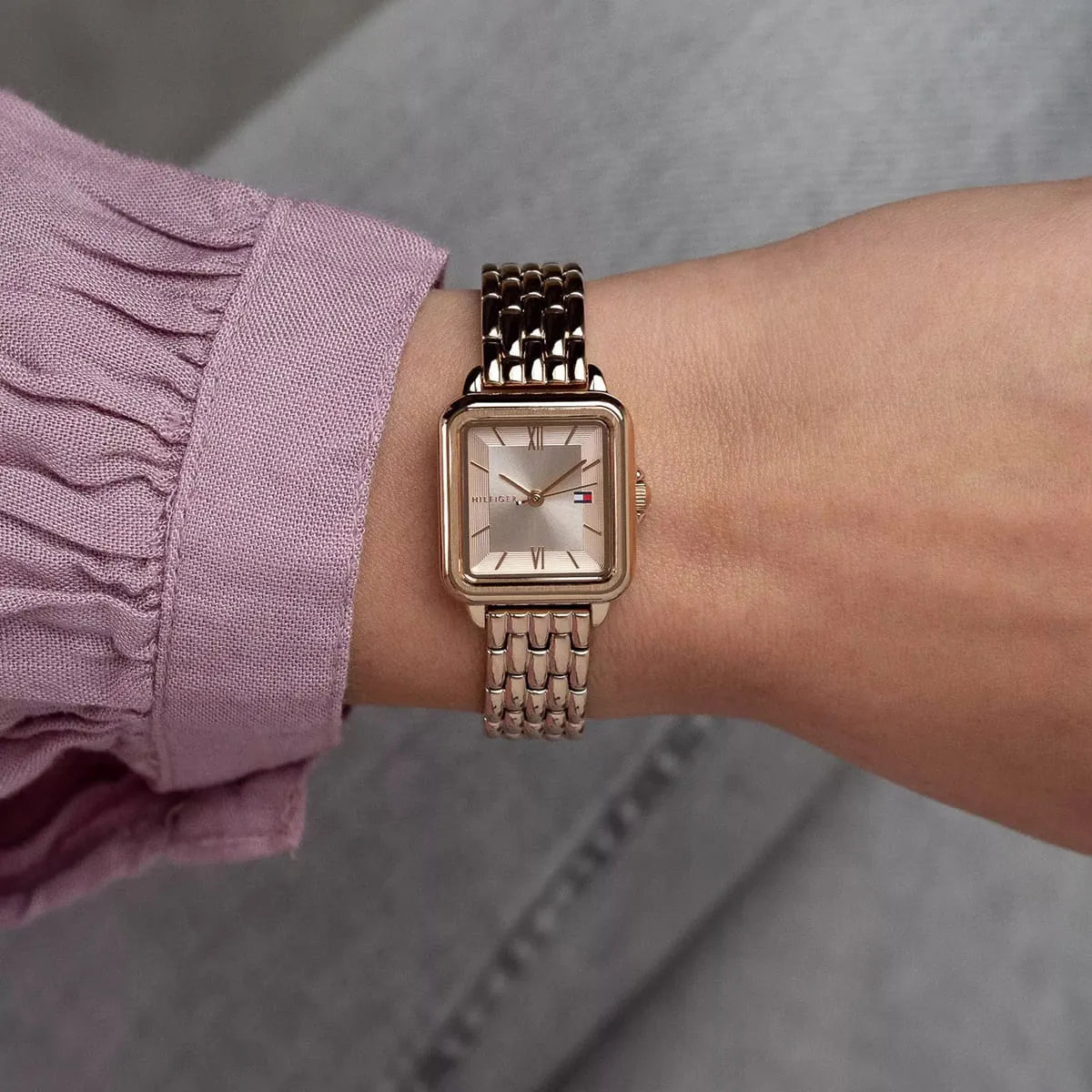 Tommy Hilfiger Mia rose gold watch worn on wrist with pink sleeve
