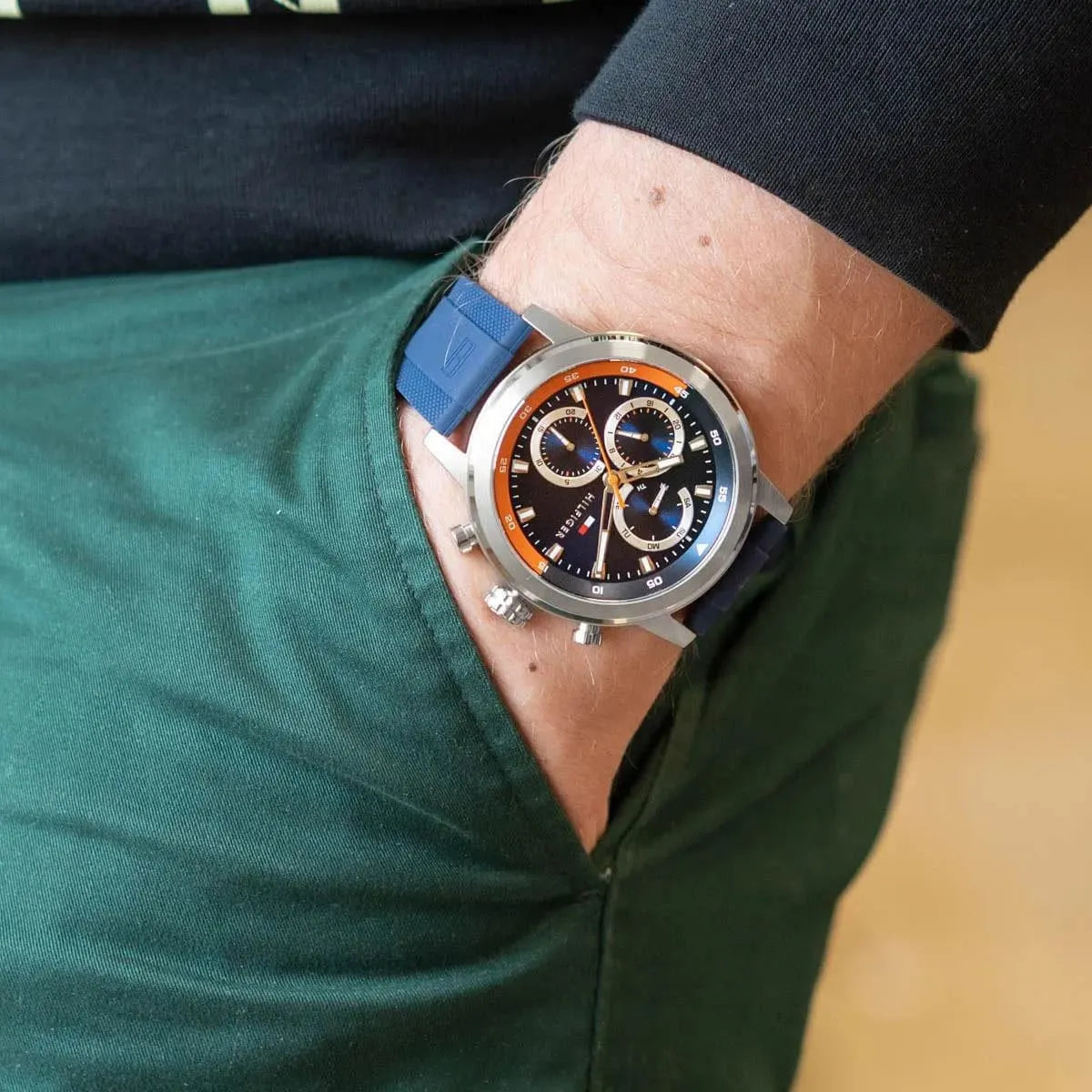Tommy Hilfiger Rocky chronograph watch worn on wrist, showing blue dial with orange accents and navy strap