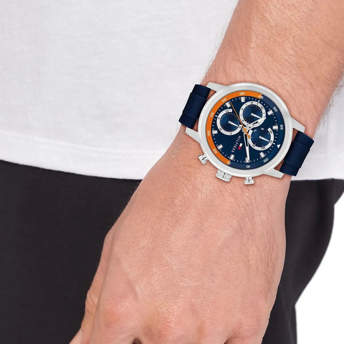 Tommy Hilfiger Rocky watch on wrist displaying full face with three subdials, navy strap, and orange bezel