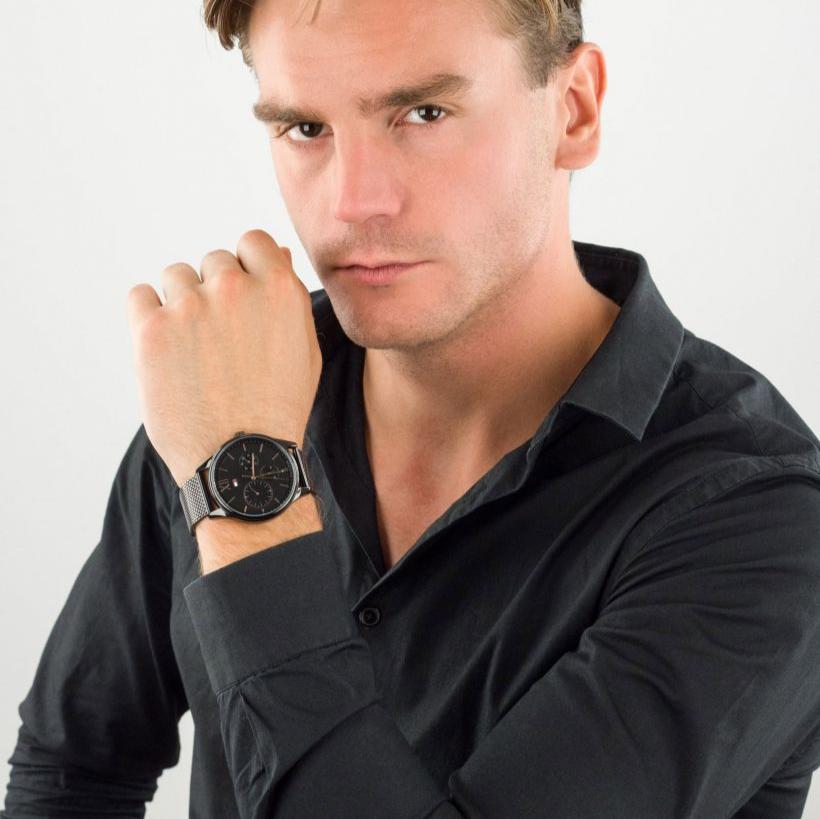 Tommy Hilfiger Weston 1710505 black chronograph watch on man's wrist in casual portrait setting