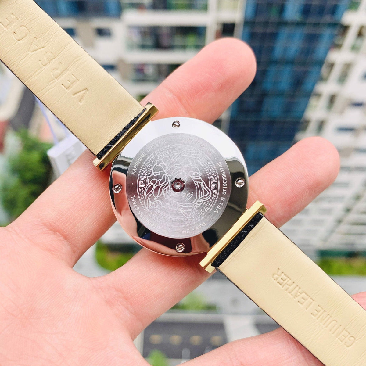 V-Twist watch held in hand showing caseback and white strap detail
