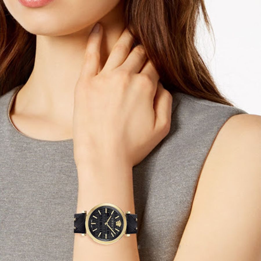 V-Twist watch worn on wrist showing black dial and gold-tone case on model