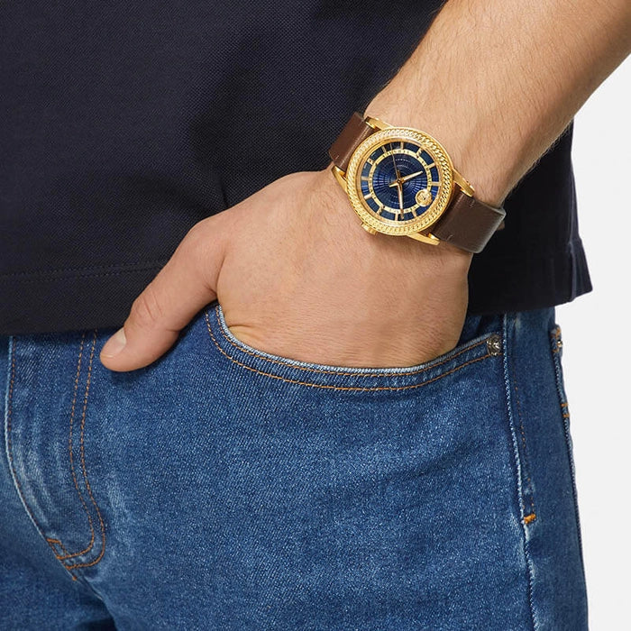 Versace Code watch worn on wrist showing blue dial and gold-plated case