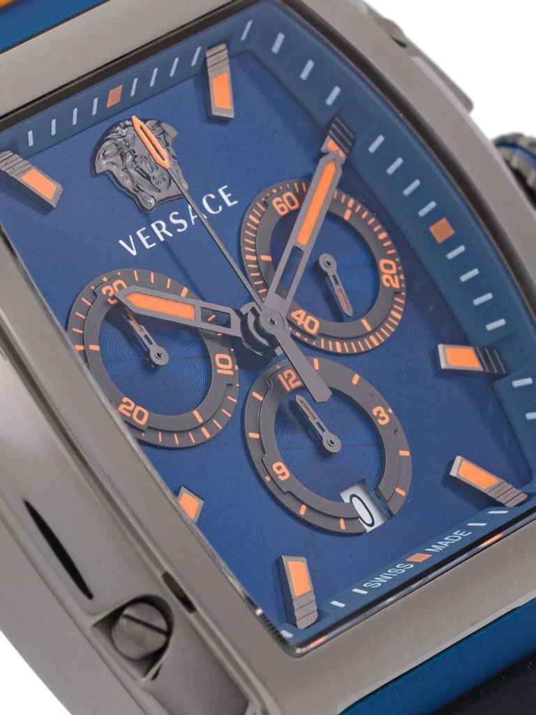 Close-up of Versace Dominus blue dial with orange chronograph subdials, hour markers, and Versace logo