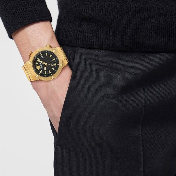 Versace Greca Logo watch worn on wrist with gold case and black dial