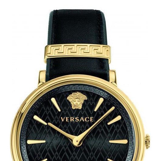 Close-up detail of Versace V Circulus watch dial showing Medusa logo, Greek key strap band, and gold-tone case