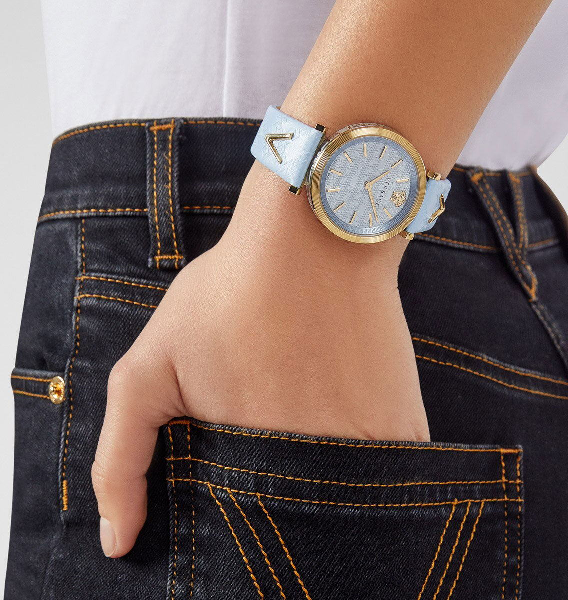 Versace V-Twist ladies watch worn on wrist with light blue strap against dark denim
