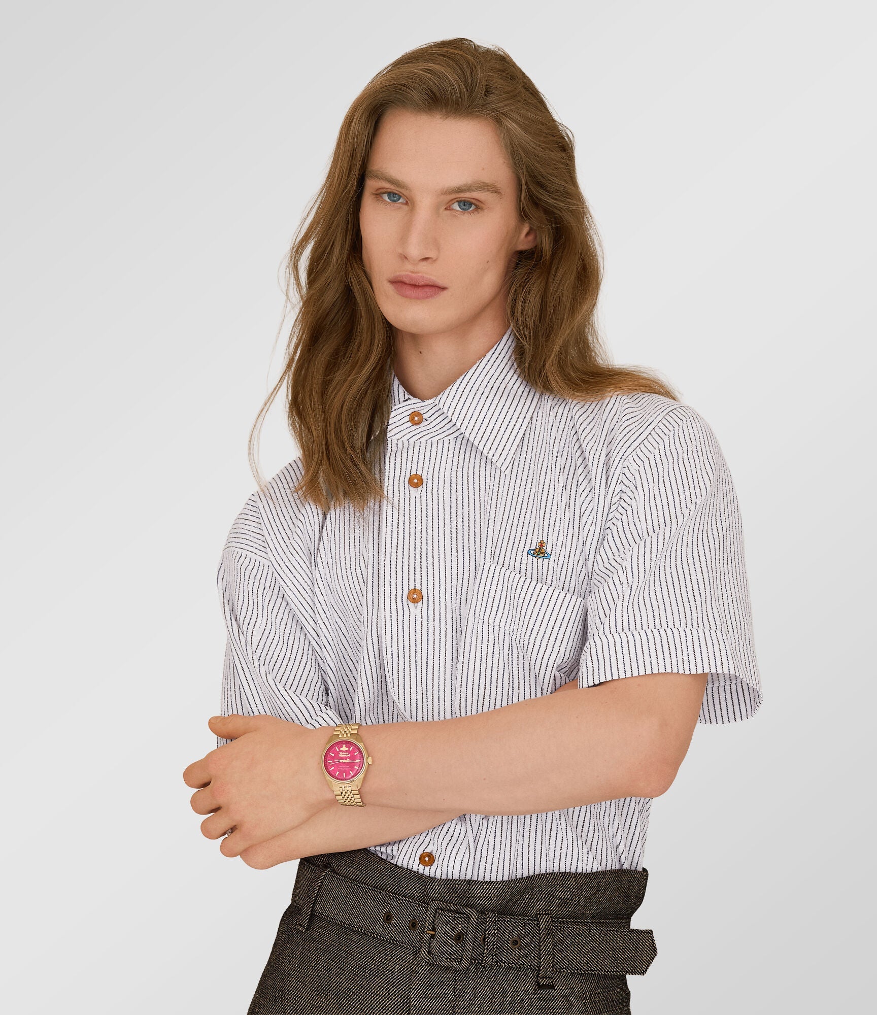 Woman wearing Vivienne Westwood Lady Sydenham gold plated watch with hot pink dial