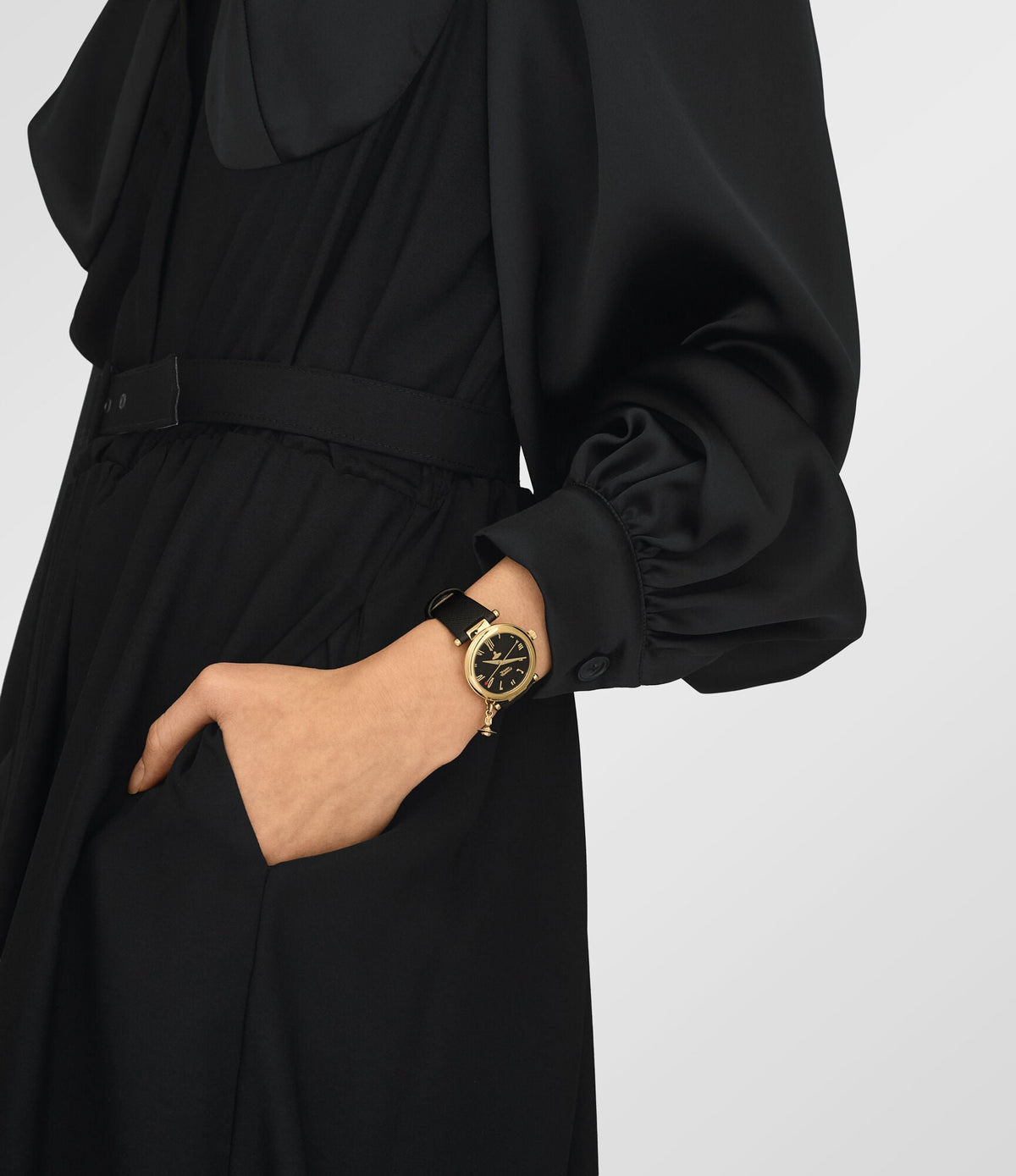 Vivienne Westwood Orb watch on wrist with gold case and black leather strap