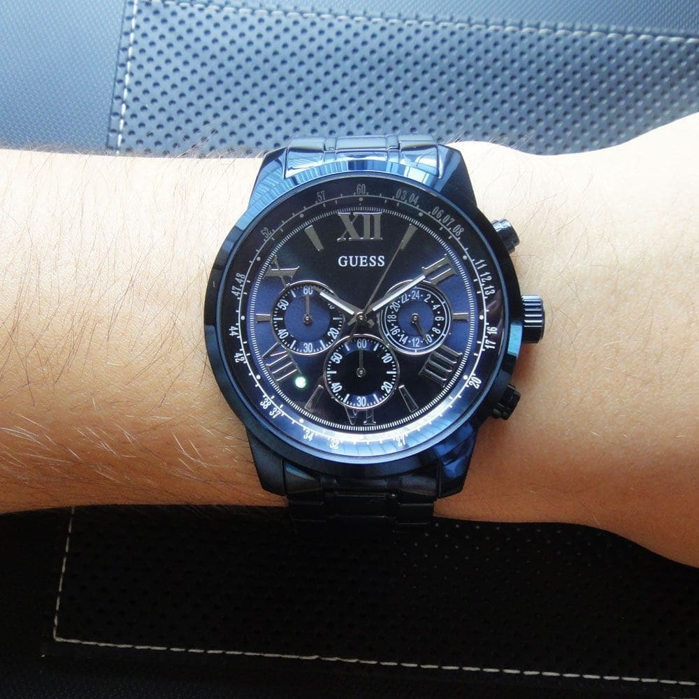 Guess Horizon chronograph watch worn on wrist showing blue steel and black dial