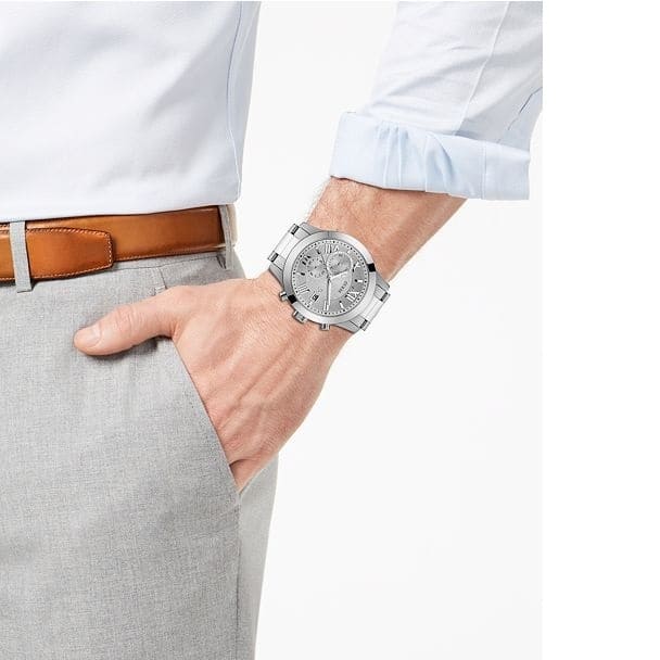 GUESS W0668G7 silver chronograph watch on man's wrist with formal attire