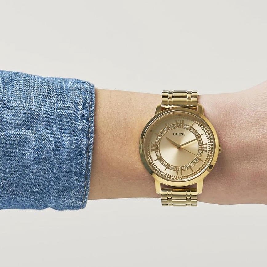 GUESS W0933L2 women's gold watch worn on wrist showing dial and metal bracelet
