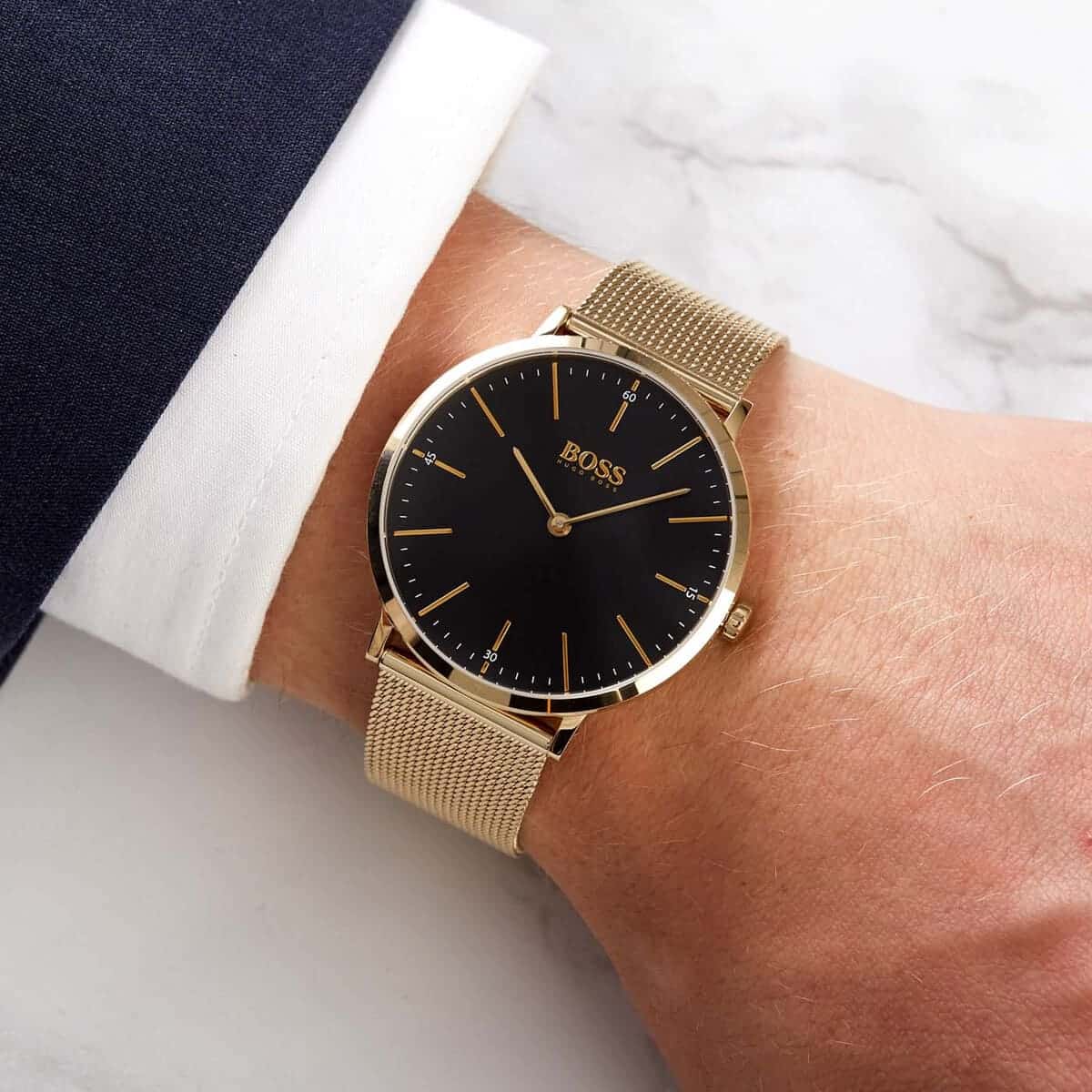 Hugo Boss Horizon men's watch on wrist showing black dial and gold mesh strap