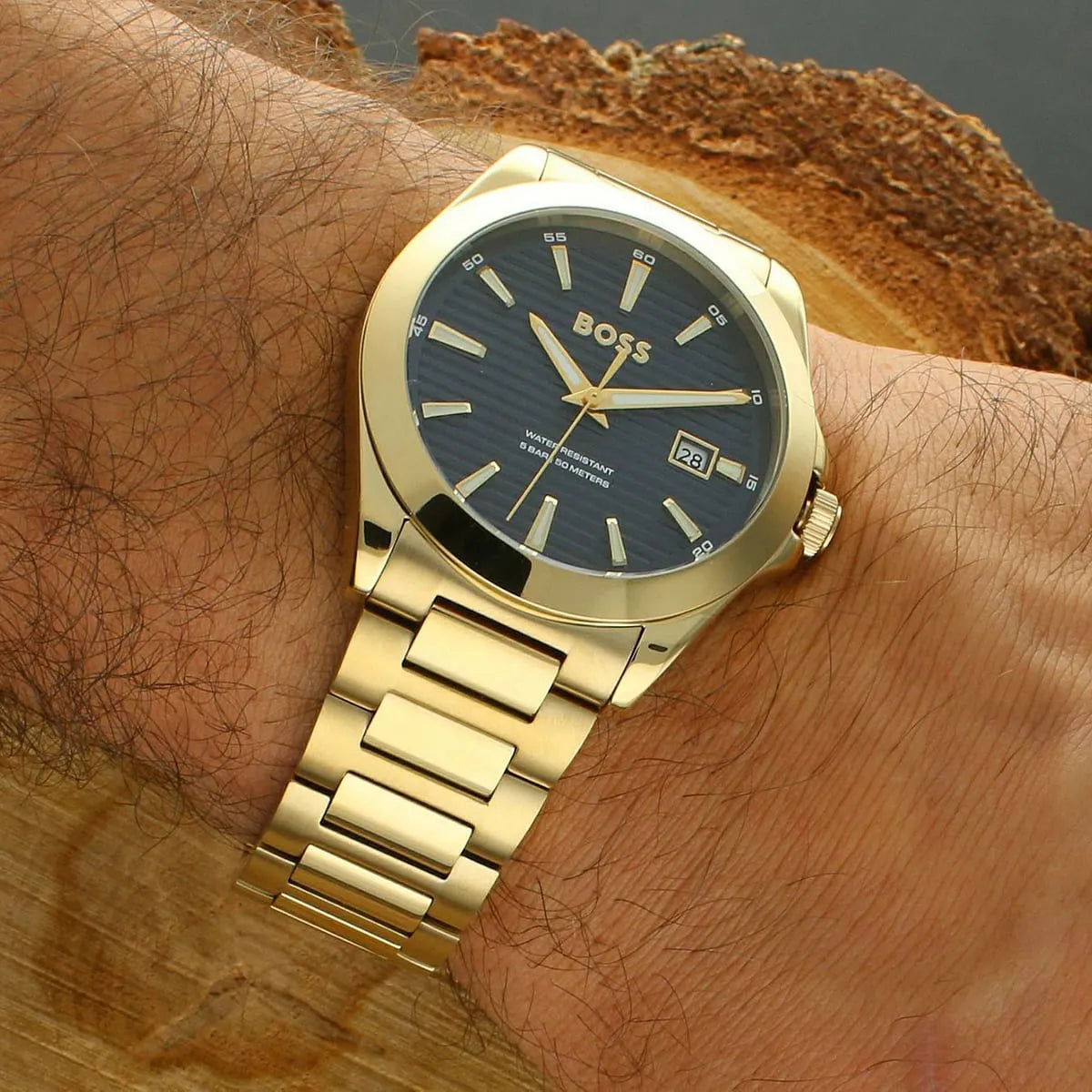 Hugo Boss Strike watch worn on wrist showing blue dial and gold steel bracelet