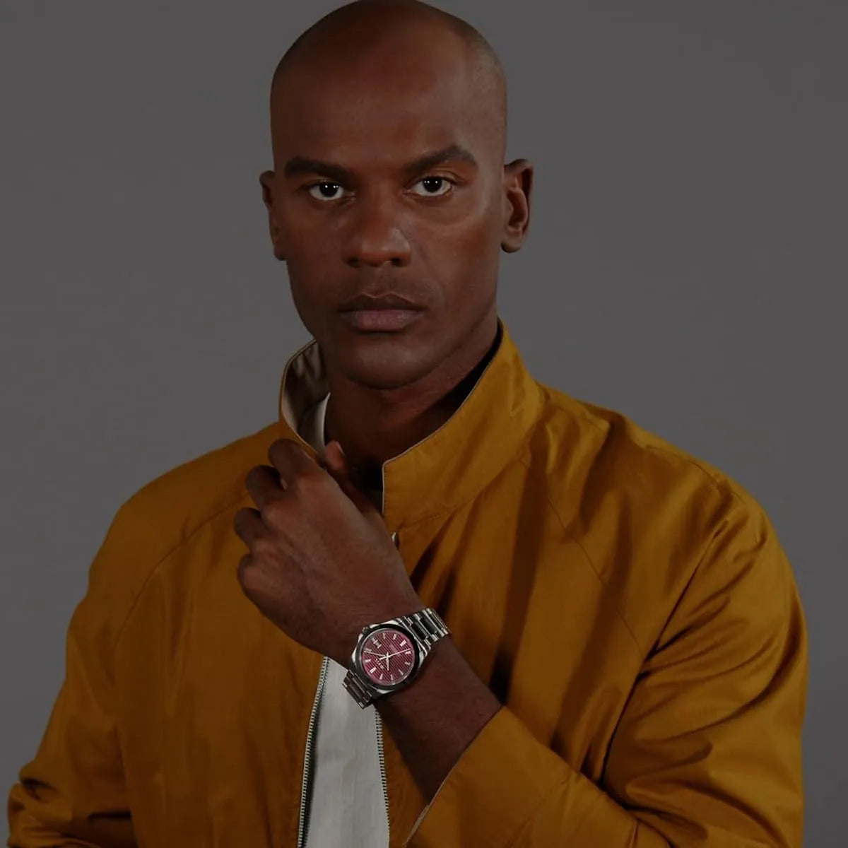 Hugo Boss Strike burgundy watch worn on wrist with yellow jacket