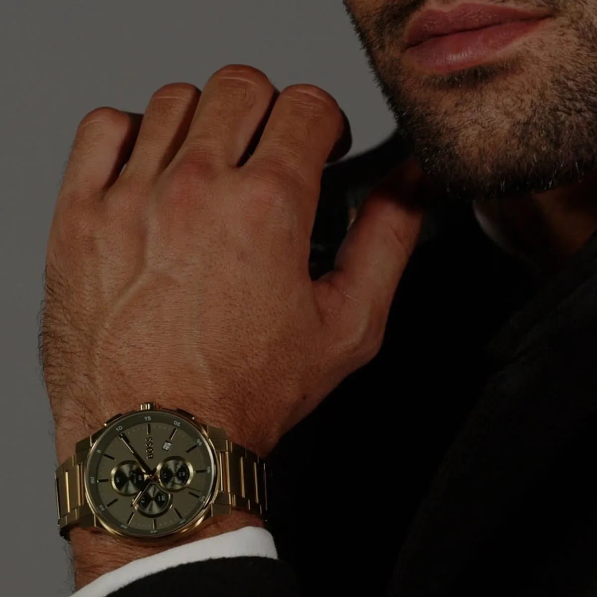 BOSS chronograph watch worn on wrist showing olive dial and gold steel case