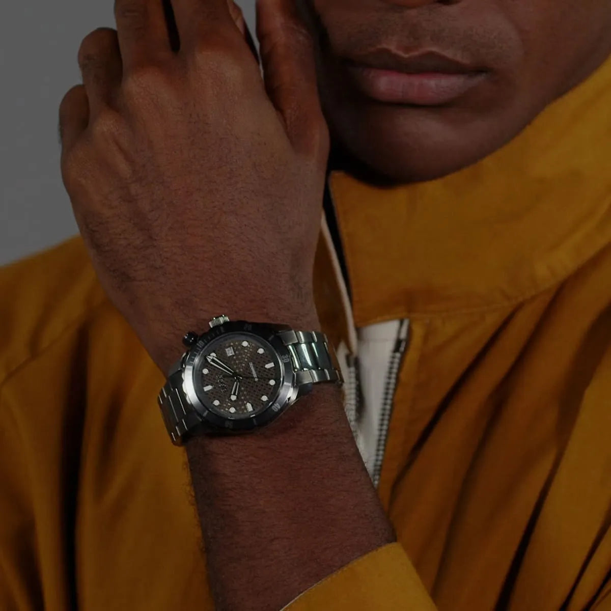 Hugo Boss gray dial stainless steel watch worn on wrist with yellow shirt