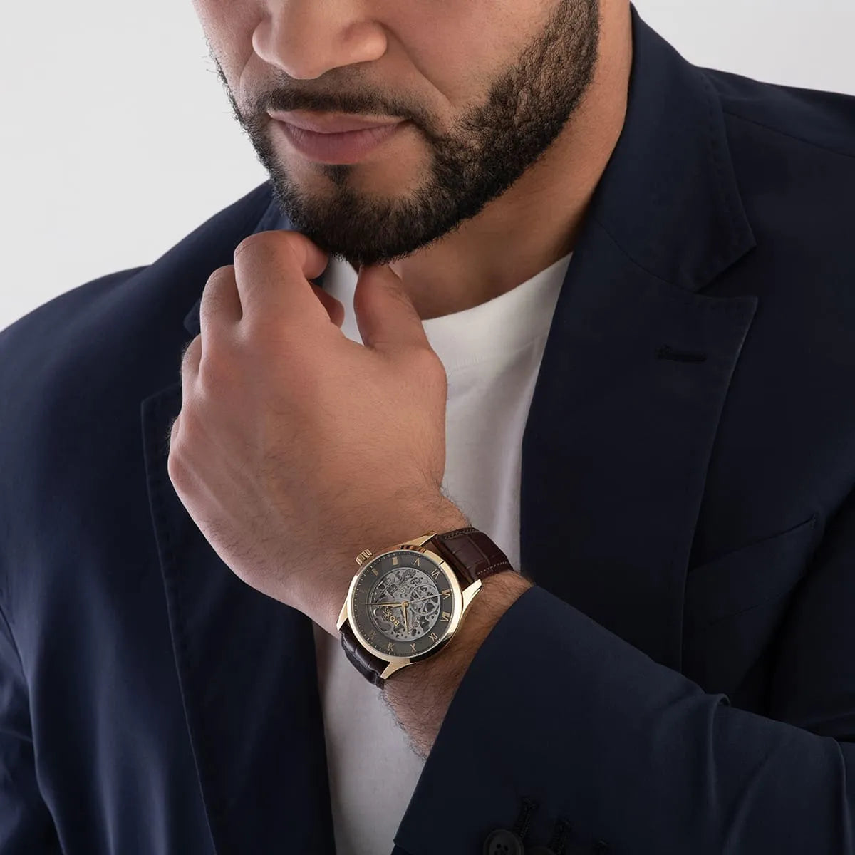 Hugo Boss skeleton automatic watch styled on wrist worn with dark blue suit and white shirt